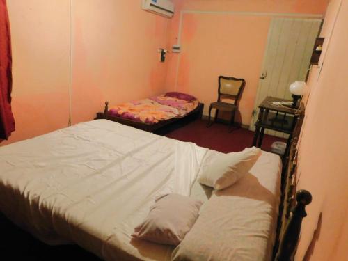 a bedroom with two twin beds and a chair at Casa 3 ambientes hasta para 5 personas in Gualeguaychú
