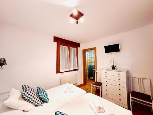 a bedroom with two beds and a dresser at Apartamento La Larri in Bielsa