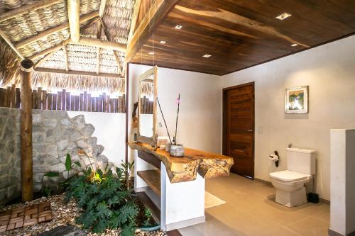 a bathroom with a toilet and a stone wall at Rancho Noé Cumbuco in Caucaia