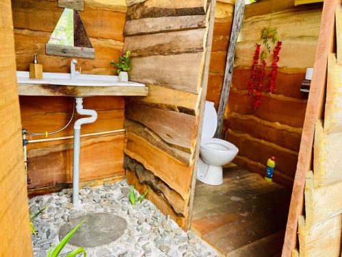 drewniana łazienka z toaletą i umywalką w obiekcie Land of Promise - Reggae Escape w mieście Zanderij