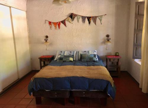 1 dormitorio con 1 cama con una pancarta en la pared en Alojamiento en Casona Bellavista, una experiencia Patrimonial-Natural, en Talca