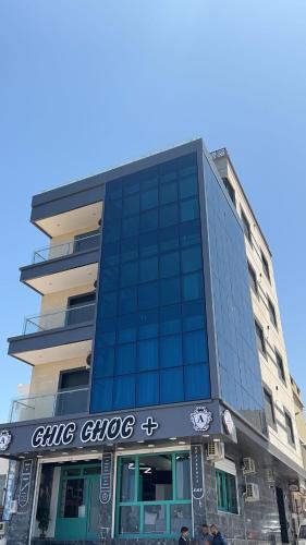 a large glass building with a sign on it at KMB APPARTEMENT in Mostaganem