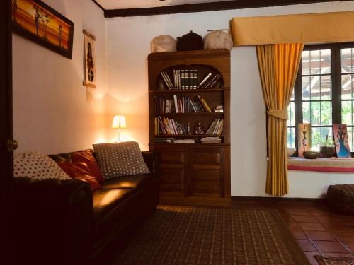 sala de estar con sofá y estante para libros en Alojamiento en Casona Bellavista, una experiencia Patrimonial-Natural, en Talca