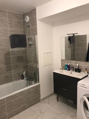 een badkamer met een bad, een wastafel en een douche bij Élégant Appartement proche Commodités - Parfait pour Jeux Olympiques 2024 in Maurepas