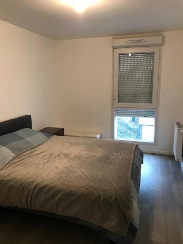 een slaapkamer met een bed en een raam bij Élégant Appartement proche Commodités - Parfait pour Jeux Olympiques 2024 in Maurepas