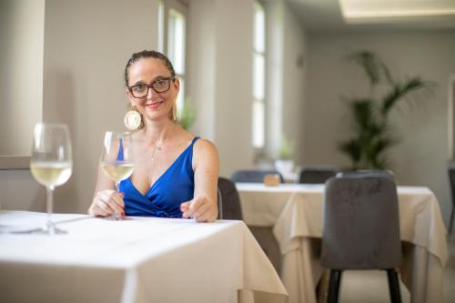 a woman sitting at a table with a glass of wine at Locanda agli Amici in Cortona