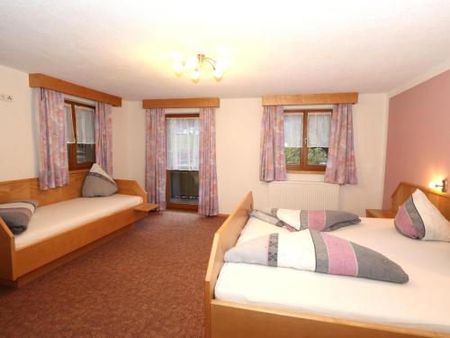 a bedroom with two beds and two windows at Apartment Höllwarth in Thurmbach