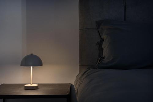 a lamp on a table next to a bed at HOME WITH VIEW in Xanthi