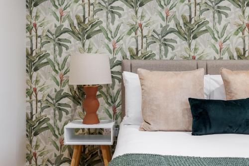 a bedroom with a bed with a lamp on a night stand at Sea Breeze - Coast in Bournemouth