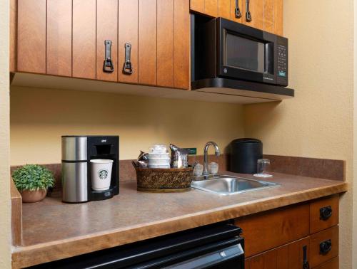 a kitchen counter with a sink and a microwave at MCM Elegante Lodge & Resorts in Ruidoso