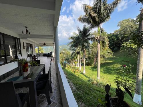 a view from the porch of a house with palm trees at Palmeras del Mirador - Hotel Boutique Campestre en La Vega a 1h de Bogotá in La Vega