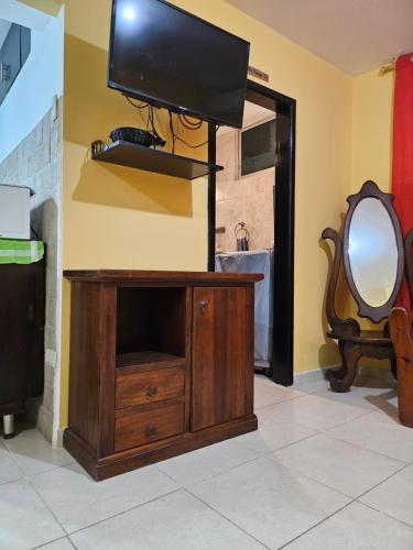 a tv on top of a dresser with a mirror at Blanca Apartments in Guayaquil