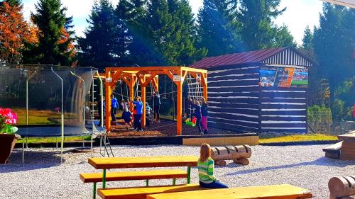 a child sitting on a bench in a playground at Penzion Zvonička in Pec pod Sněžkou