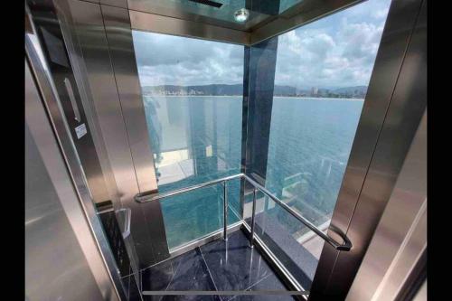 a view of the water from a glass balcony on a boat at Mansão com vista cinematográfica pro mar! in Guarujá