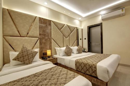 a hotel room with two beds and a wall at BLESS INN - Near Connaught Place in New Delhi