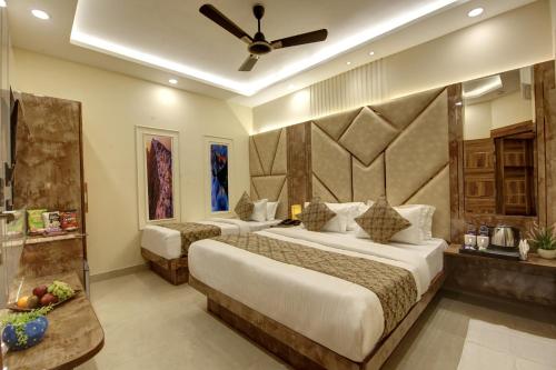 a hotel room with two beds and a ceiling fan at BLESS INN - Near Connaught Place in New Delhi