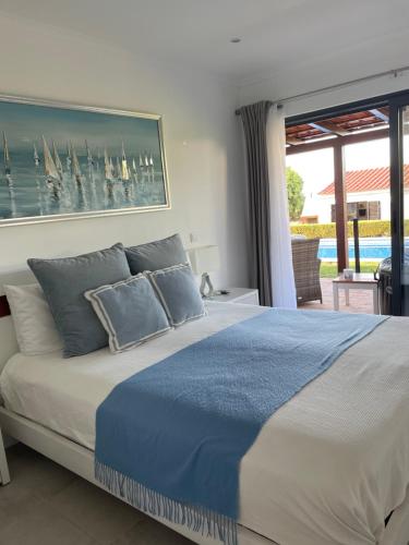 una camera da letto con un grande letto con cuscini blu di Villa Sol a Portimão