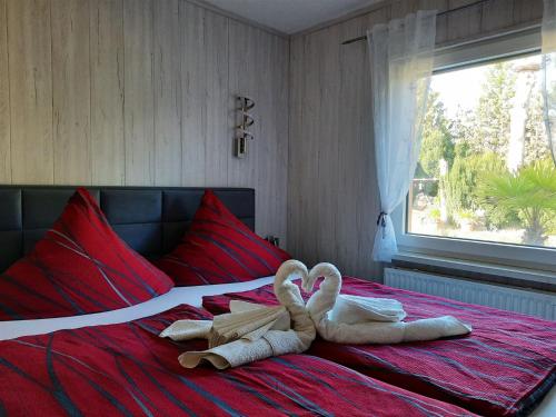 Dos toallas en forma de corazón están en una cama en Haus Seeblick, en Roßbach