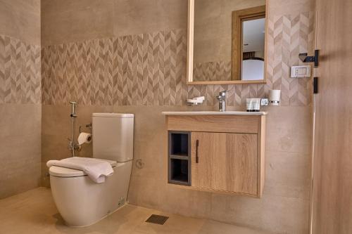 a bathroom with a toilet and a sink and a mirror at Lotus Inn in Cairo