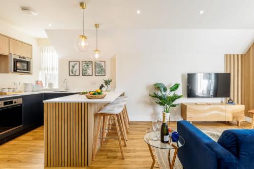 a kitchen and living room with a blue couch at Sea Breeze - Coast in Bournemouth