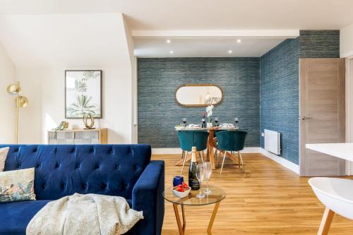 a living room with a blue couch and a table at Sea Breeze - Coast in Bournemouth