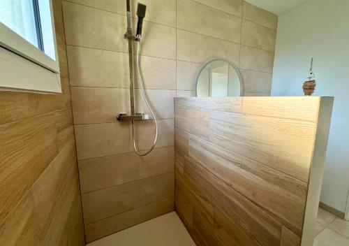 La salle de bains est pourvue d'une douche et d'un comptoir en bois. dans l'établissement Douce Évasion, à Biscarrosse