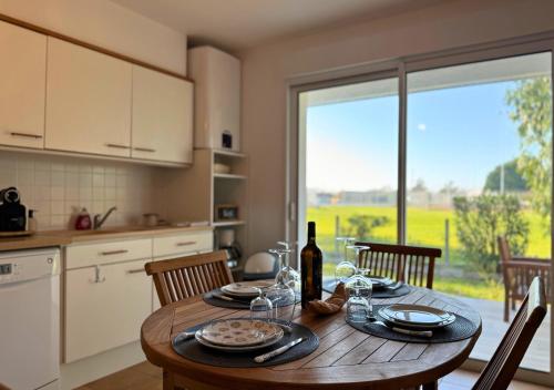 - une cuisine avec une table en bois et une bouteille de vin dans l'établissement Douce Évasion, à Biscarrosse