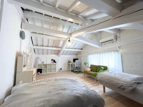 una camera con un grande letto e un divano di ゲストハウスでたらめ荘 a Yamakami