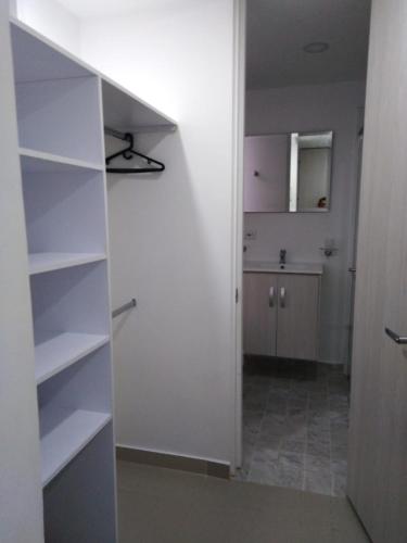 a room with white shelves and a kitchen at Apartamento 3 hab 2 baños in Santa Rosa de Cabal