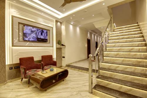 a lobby with a staircase and a couch and a table at BLESS INN - Near Connaugt Place in New Delhi