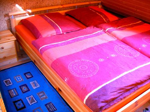 two beds with colorful blankets and pillows on them at waldhaus no 15 in Mönkebude