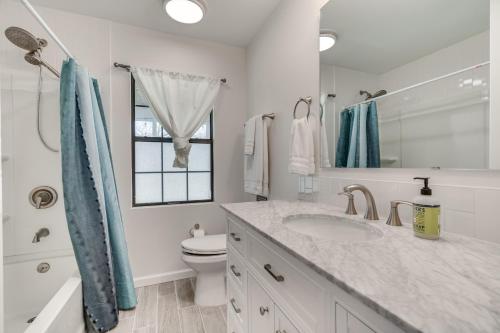 a bathroom with a sink and a toilet and a window at Charming Austin Home on 2 Acres BBQ and Yard! in Bee Cave