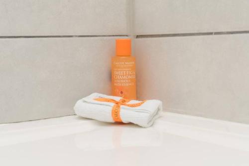 a towel with an orange ribbon next to a bottle of glue at London Bermondsey 3 People Beautiful Studio in London