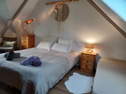 una camera da letto con un letto e asciugamani di La maison au cœur de la forêt a Rosporden