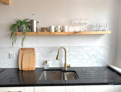 a kitchen sink with a wooden cutting board next to it at Beautiful sea view, tranquil loft apartment in Lytham St Annes