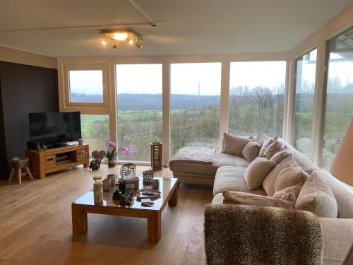 a living room with a couch and a table at Gîte Le Chalet Suisse Dion in Beauraing