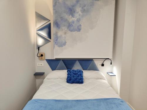 a bedroom with a bed with a blue pillow on it at ELEGANCIA Y MODERNIDAD EN PLENO CENTRO in Oviedo