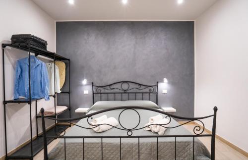 - une chambre avec un lit noir et un mur gris dans l'établissement Saverio's apartment, à Tropea