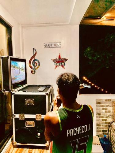a man is standing in front of a microwave at Samantha's Cove Priv Beach House in Oslob