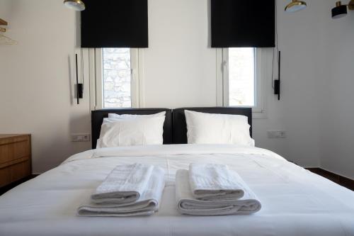 two towels on a bed with two pillows on it at Arion Aegli in Agioi Theodoroi