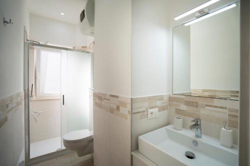 ein Badezimmer mit einem Waschbecken, einem WC und einem Spiegel in der Unterkunft Saverio's apartment in Tropea