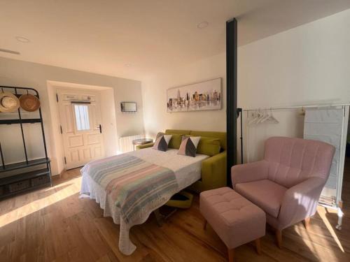 una camera da letto con un letto e una sedia di Terraza Bolingas a Comillas