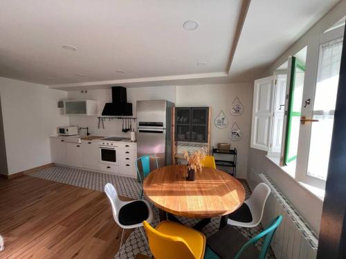 una cucina con tavolo in legno e sedie gialle di Terraza Bolingas a Comillas