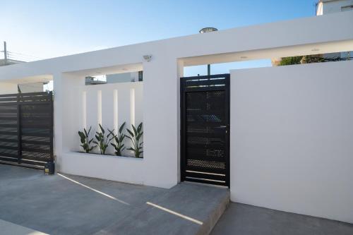 a garage with black doors and plants on the wall at Arion Aegli in Agioi Theodoroi