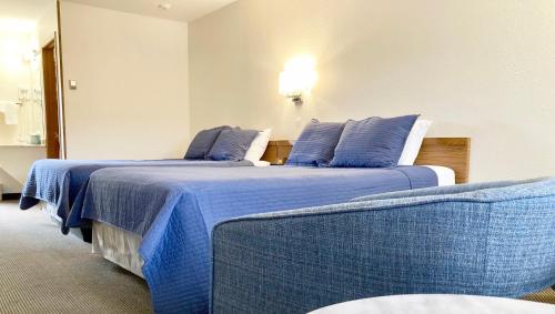 2 Betten in einem Hotelzimmer mit blauen Kissen in der Unterkunft Big Horn Lodge in Grand Lake