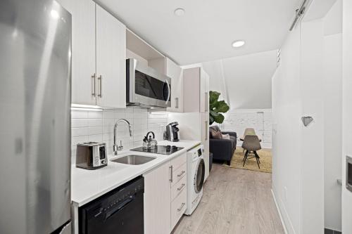 a white kitchen with a sink and a refrigerator at Placemakr Dupont Circle in Washington