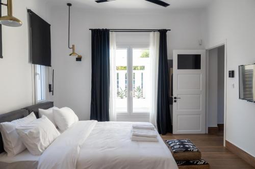 a bedroom with a large white bed and a window at Arion Aegli in Agioi Theodoroi