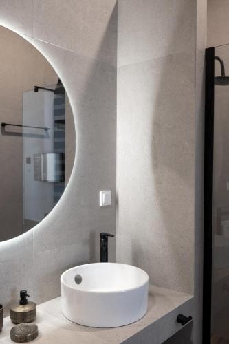 a bathroom with a white sink and a mirror at Arion Aegli in Agioi Theodoroi