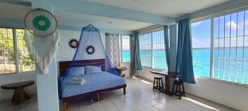 a bedroom with a bed with a view of the ocean at Casa Agua Bacalar / Naajil Ha in Bacalar
