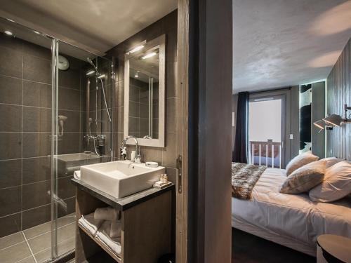 uma casa de banho com um lavatório, um chuveiro e uma cama. em Appartement Courchevel 1650, 6 pièces, 10 personnes - FR-1-563-14 em Courchevel